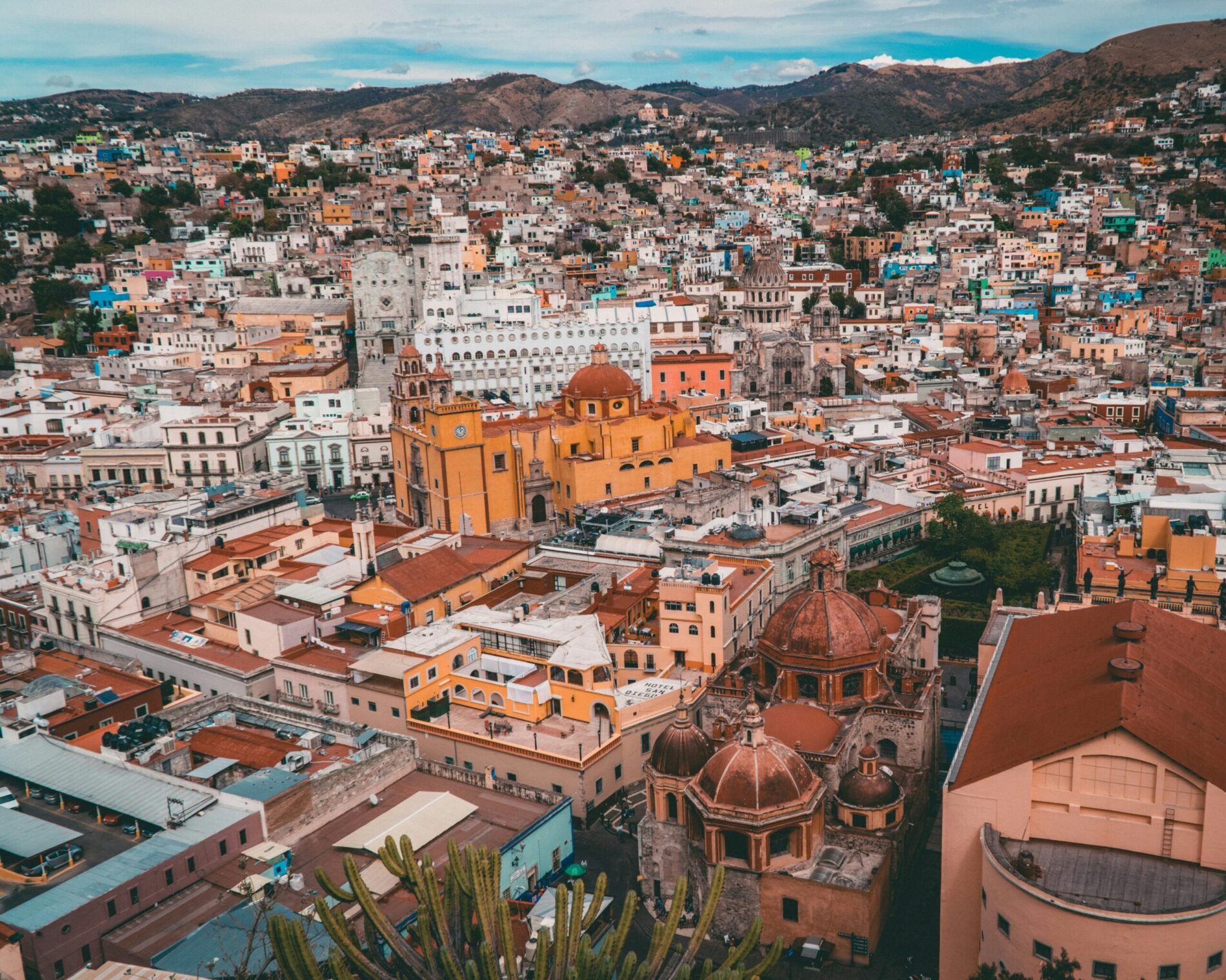 Moving to Mexico from the USA – colorful hillside houses and church in Guanajuato, central Mexico