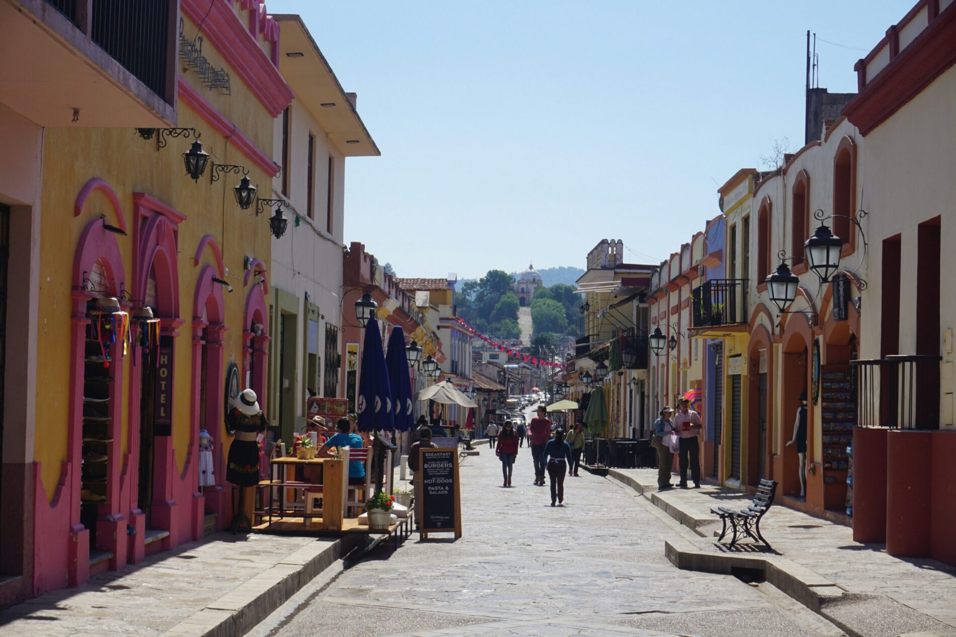 Pastel colonial buildings line a cobbled street in a Mexican town