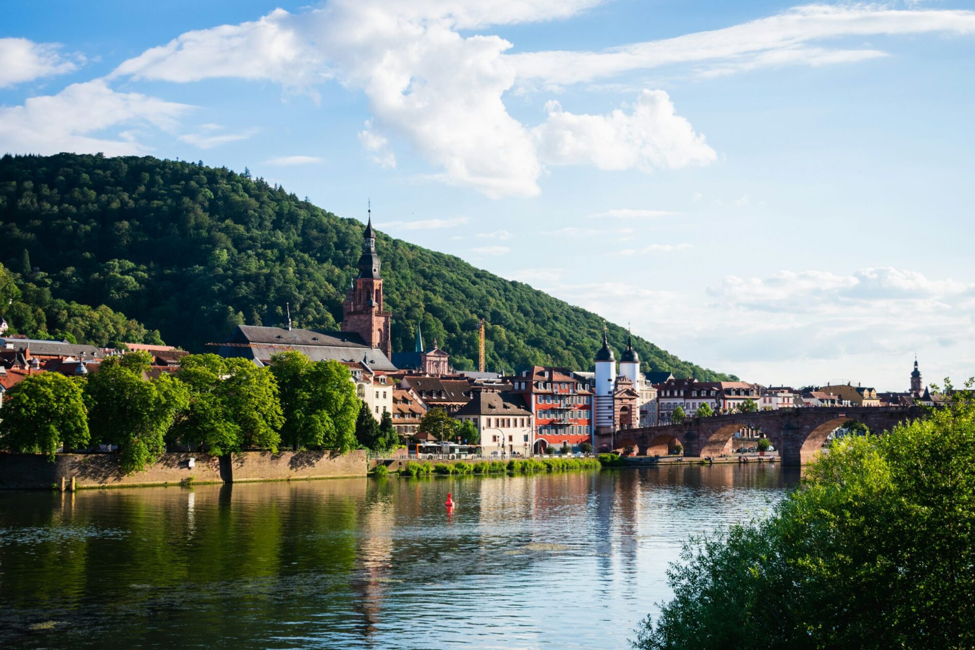 German riverside town beneath wooded hills, typical of the regional hubs hiring for jobs in Germany for Americans