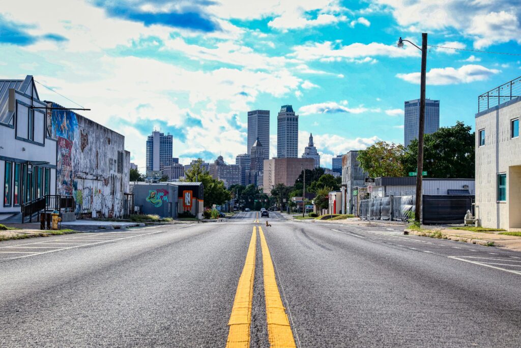 A wide open city road leading toward the modern downtown skyline of Tulsa, Oklahoma
