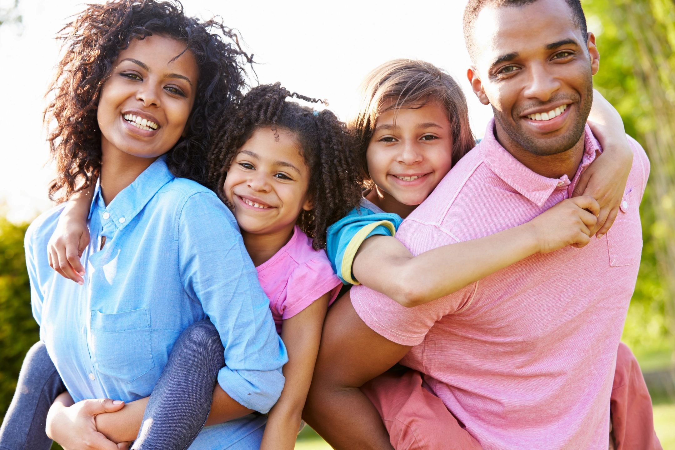 Parents and two children smiling together outdoors while planning their move abroad